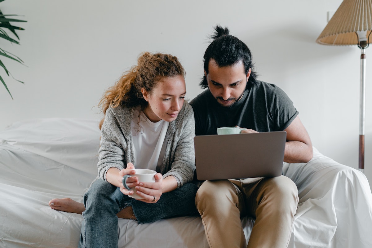 Couple on a computer together, studying the local housing market